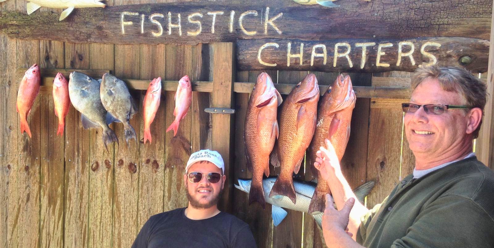 Guests with snapper at the Fishstick Charters sign
